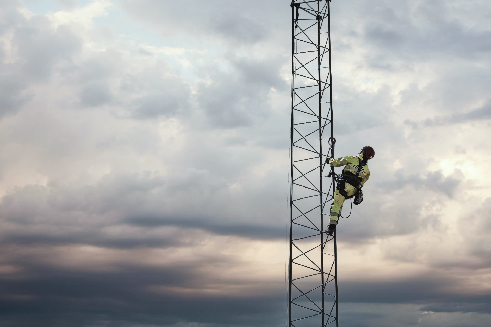 Technician climbing a tower with safety harness