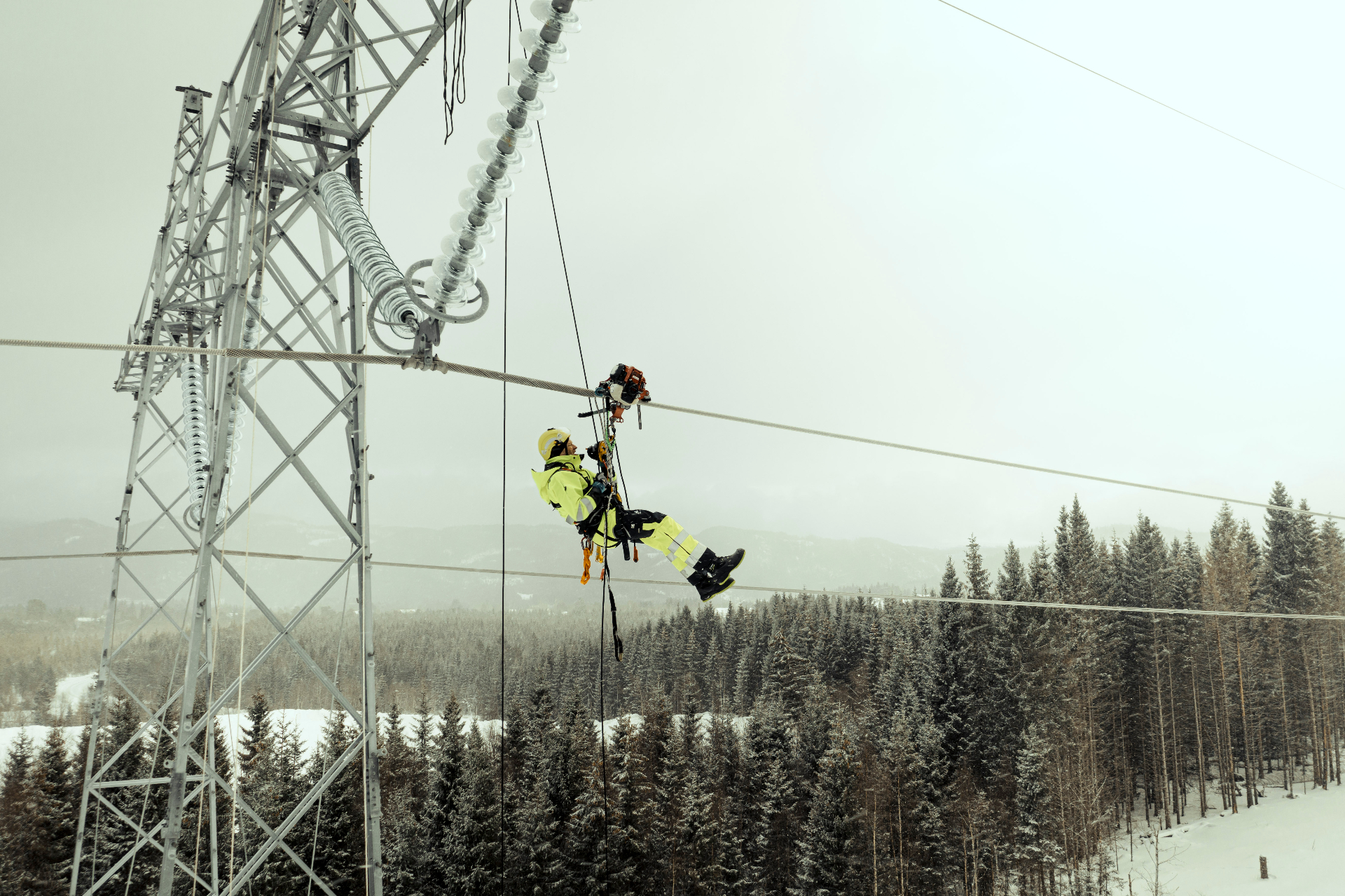 Technician working on power line in winter conditions